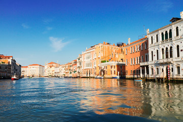 Obraz premium muticolored Venice houses and reflections over water of Grand canal with boats, Italy