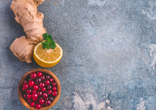 Plastered background with ginger, lemon and cranberries with copy space