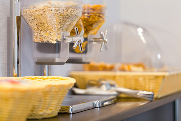 Cereal dispensers offering some kind of cereals on a self service breakfast in a hotel restaurant