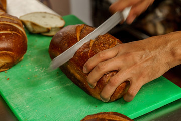 Freshly baked bread to be cut into a restaurant kitchen. - 139347199