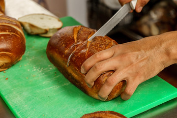 Freshly baked bread to be cut into a restaurant kitchen. - 139347332