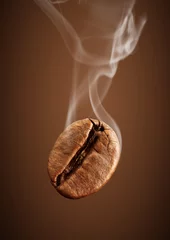 Zelfklevend Fotobehang Closeup falling coffee bean with smoke on brown background © dimj