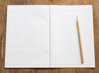 Blank notebook with pencil on wooden table, business concept.