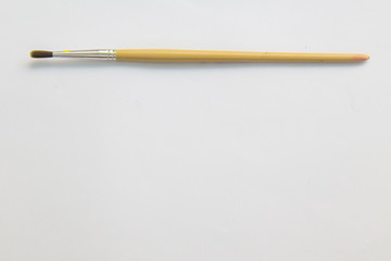 Paintbrush on white paper with working space.