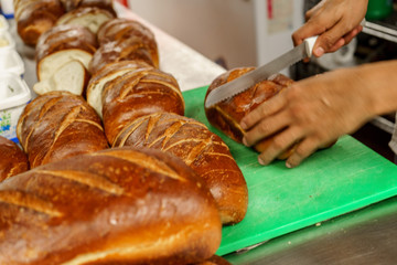 Freshly baked bread to be cut into a restaurant kitchen. - 139347955
