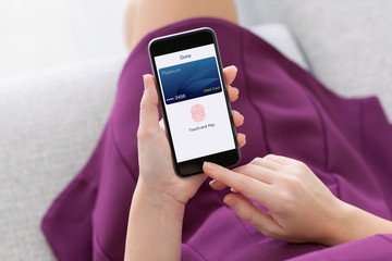 woman holding phone with debit card app touch pay