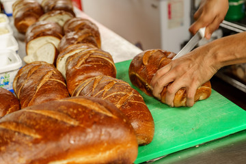 Freshly baked bread to be cut into a restaurant kitchen. - 139348173