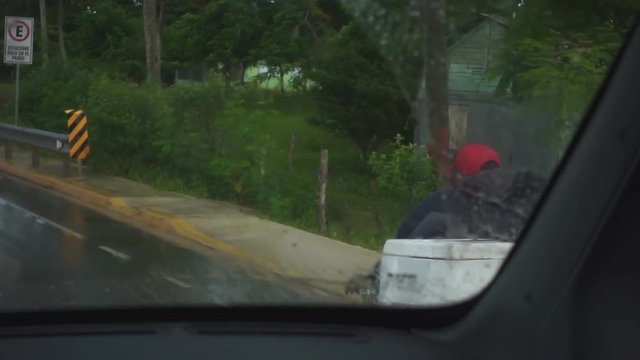A local resident rides a bicycle with a big white box in the rain