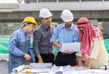 business people group on meeting and presentation with construction engineer architect looking building model and blueprint plans