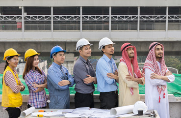 business, building, teamwork and people concept - group of smiling builders in hardhats outdoors