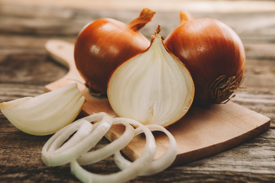 Onion bulb on chopping board with onion slices