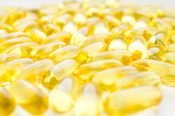 Fish oil fat capsules with omega 3 and vitamin D on white background, healthy diet concept