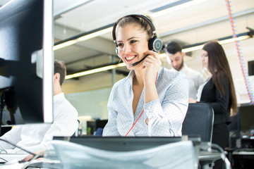 Smiling agent woman with headsets. Portrait of call center worker at office.