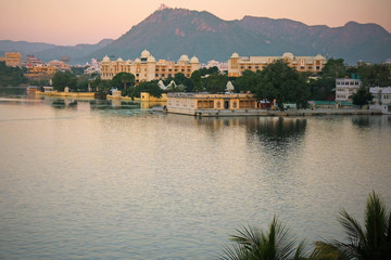 Fototapeta premium The city of Udaipur at dusk in early winter. It is situated on the edge of Lake Pichola and surrounded by the Aravalli Hills in Rajasthan