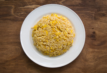 Asian fried rice with eggs on wooden background.