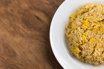 Asian fried rice with eggs on wooden background.