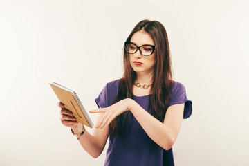 Student girl attentively reading book, free space. Portrait of young woman in glasses carefully studing material in textbook. Study, education, unclear information concept