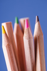 group of sharpened colorful pencils on blue background.