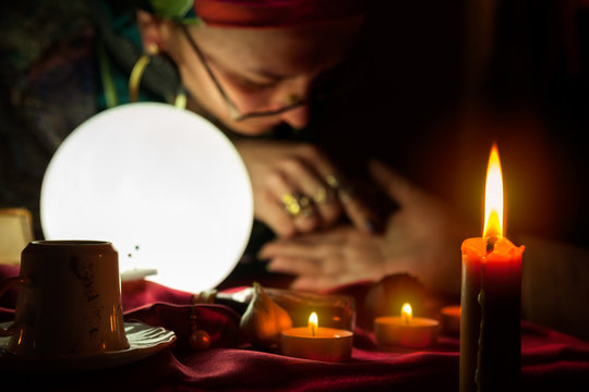 Burning candle and fortune teller who read a fortune from palm