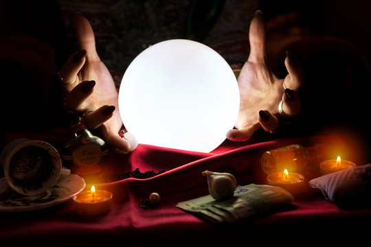 Hands of fortune teller with crystal ball in the middle
