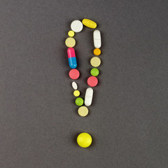 Exclamation point created from colored pills. Medical concept