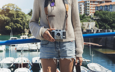 Tourist traveler photographer making pictures sea scape on vintage photo camera on background yacht...