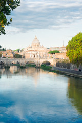 Fototapeta na wymiar St. Peter's cathedral over bridge and river Tiber water in Rome, Italy
