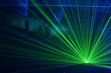 Unrecognizable people watching a beautiful laser show with multicolored lights
