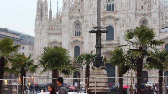 People walking near the Milan duomo with palms