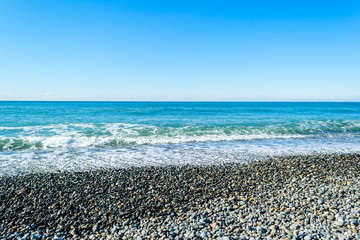 Waves breaking on a stony beach, forming sprays