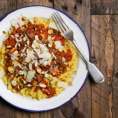 Italian pasta with tomato sauce, smoked pancetta, roasted almonds and parmesan cheese