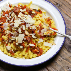 Italian pasta with tomato sauce, smoked pancetta, roasted almonds and parmesan cheese
