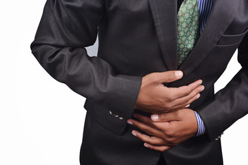 Business man having stomach pain in black suit isolated on white background