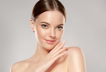 Beautiful Young Woman with Clean Fresh Skin touch own face . Facial treatment . Cosmetology ,...