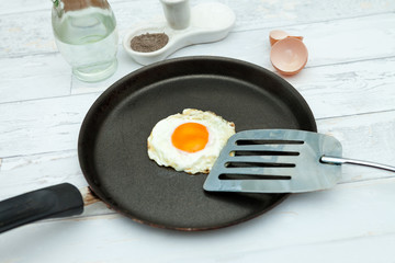 Fried egg in shape of heart in a pan