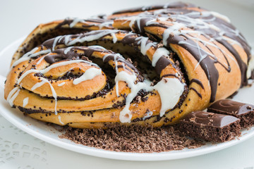 Roll dough with poppy-seeds and chocolate and dairy glaze