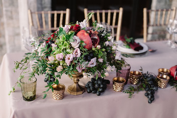 Wedding table decoration with the pink flowers, pomegranate and greenery