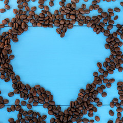 favorite brand coffee/ flat layout of the roasted beans forming a heart shape on blue wooden surface