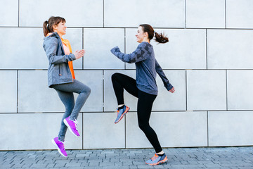 Fototapeta premium Full leight of two sporty women face to face exercising for marathon and workout fitness
