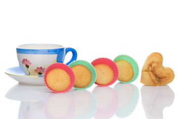 Cup of tea with a heart cake and silicon baking dishes. White background.