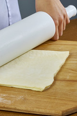 Roll out the dough Closeup hand of chef baker in uniform blue apron cook pizza at kitchen complete collection of recipes