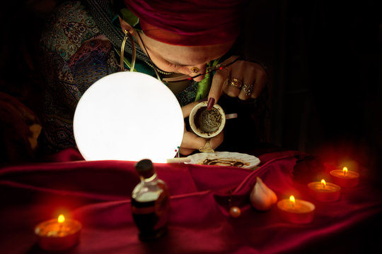 Gypsy clairvoyant woman reads a fortune from empty coffee cup