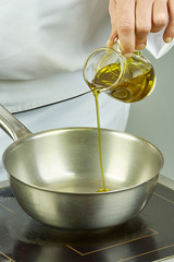 Chef pours oil into the pan for cooking series full cooking food recipes