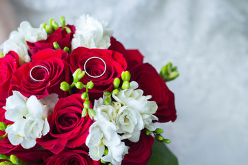Wedding rings closeup on the flower bouquet of the bride