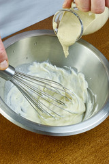 Fototapeta na wymiar chef whisk mayonnaise in a bowl in hand a series of full cooking food recipes