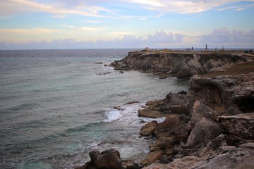 Obraz premium Caribbean Sea meets rocky shore of Isla Mujeres, Mexico.
