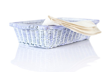 Obraz premium Wicker basket and napkin on white