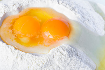 Eggs in flour. Preparation for baking. Detail of the egg yolk. Raw materials for the production of dough.