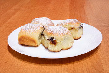 Czech baked buns with jam and sugar. Baking cakes. Traditional Czech recipe for buns. Festive delicacies. Buns on a plate.