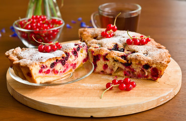 Piece of berry pie on saucer and tea